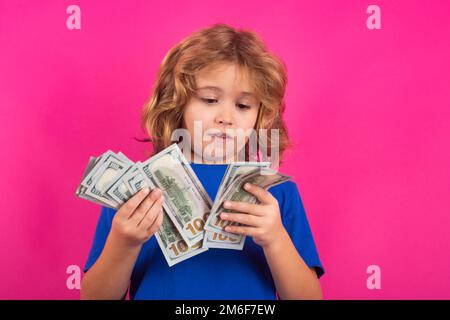 Bargeld in Dollar-Banknoten. Ein Junge mit hundert Dollar Geld, isoliert im Studiohintergrund. Stockfoto