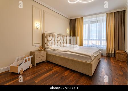 Moderne beigefarbene Schlafzimmer mit Doppelbett Stockfoto