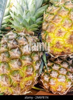 Vertikaler Rahmen, Nahaufnahme von Ananas, Draufsicht, Hintergrund mit vielen Ananasfrüchten Stockfoto