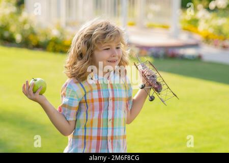 Kinderspiel. Kind, das mit Flugzeugflügeln spielt. Sommerkinder auf dem Land. Kindheitserinnerungen, Traum-Fantasie-Konzept. Aktives Kind spielt im Freien Stockfoto