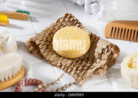 Umweltfreundliche, solide Shampoo-Bar und natürliche Toilettenartikel auf Wabenpapier, weißer Badezimmerhintergrund. Ohne Plastik, ohne Abfall Stockfoto