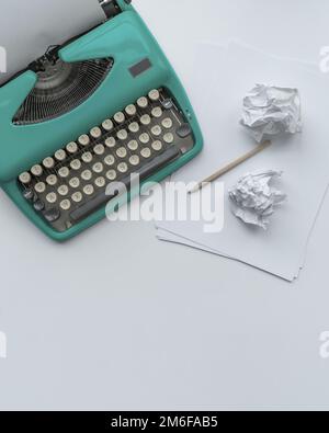 Eine Vintage-Schreibmaschine mit Papierblättern, Schablone und Papierkugeln. Stockfoto