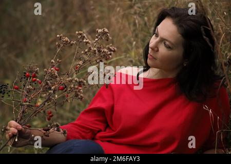 Schöne 30-jährige Frau entspannt im Herbstpark Stockfoto