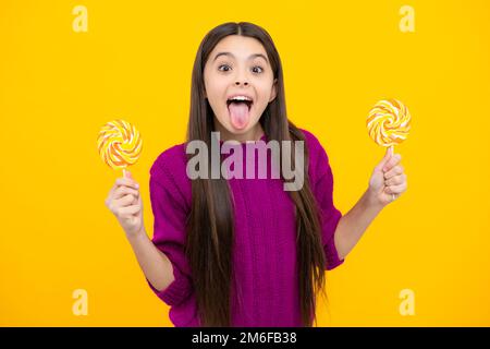 Komisches Gesicht. Hipster Teenager Mädchen Leck Lollypop. Zuckernahrung, Süßigkeiten und Süßigkeiten. Das Kind isst Lollipop-Eis am Stiel. Stockfoto