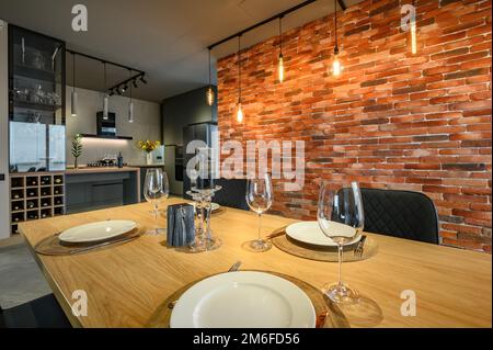 Moderne luxuriöse dunkelgraue und schwarze Küche mit Esstisch Stockfoto