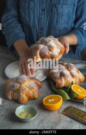 Frau, die Pan de muertos Brot der Toten für den mexikanischen Tag der Toten bereitet. Stockfoto