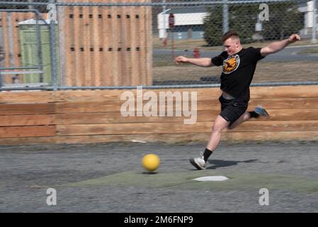 USA Kimble Peterson, Petty Officer der Küstenwache aus der 3. Klasse, spielt Kickball während einer moralischen Veranstaltung, die vom Stützpunkt Kodiak Chief in Kodiak, Alaska, am 27. April 2022 ausgerichtet wird. Ziel der Chiefs war es, an einem sonnigen Tag Personal aus verschiedenen Einheiten auf der Basis zusammenzubringen. USA Foto der Küstenwache von Petty Officer 3. Klasse Janessa-Reyanna Warschkow Stockfoto