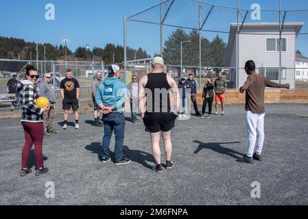 USA Mitarbeiter der Küstenwache spielen Kickball während einer moralischen Veranstaltung, die am 27. April 2022 von der Basis Kodiak Chiefs in Kodiak, Alaska, ausgerichtet wird. Ziel der Chiefs war es, an einem sonnigen Tag Personal aus verschiedenen Einheiten auf der Basis zusammenzubringen. USA Foto der Küstenwache von Petty Officer 3. Klasse Janessa-Reyanna Warschkow Stockfoto