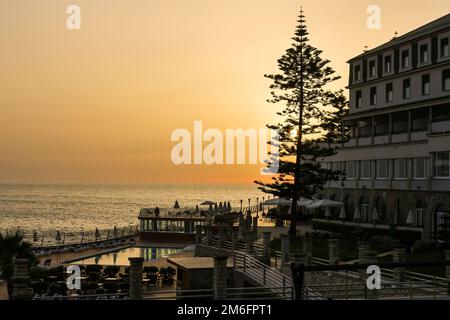 Ein goldener Sonnenuntergang über dem Hotel Vila Gale im Dorf Ericeira, Portugal Stockfoto