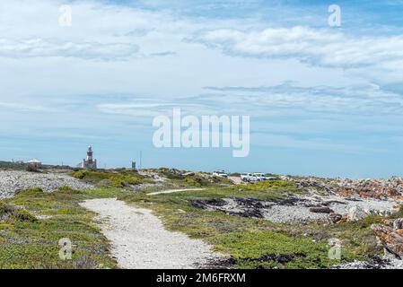 L'Agulhas, Südafrika - 22. September 2022: Blick vom südlichsten Punkt Afrikas, Cape L'Agulhas in Richtung Leuchtturm und Parkplatz Stockfoto