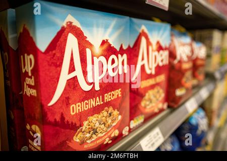 Surrey UK - Dezember 2022: Alpen-Boxen auf Supermarktregalen – eine Reihe von Müsli-Sorten, die von der Getreidefirma Weetabix hergestellt werden Stockfoto