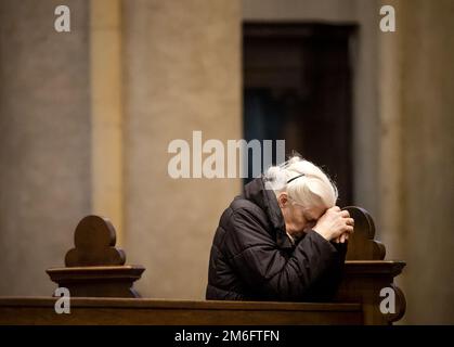 ROERMOND - Ein Kirchgänger betet während einer Gedenkfeier für Papst Emeritus Benedict XVI. In St. Christophers Kathedrale. Benedict starb im Alter von 95 Jahren. Er war von 2005 bis 2013 Papst und trat aus gesundheitlichen Gründen zurück. ANP SEM VAN DER WAL niederlande raus - belgien raus Stockfoto