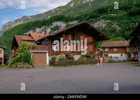 Schöne traditionelle Holzhäuser in einem malerischen kleinen Dorf am Brienzer See - den Schweizer Alpen - Iseltwald, Schweiz Stockfoto