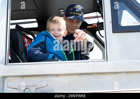 BM3 Andrew Oats und ein Student von LEARN DC machen am 27. April 2022 eine Pause für ein Foto, während sie ein 29-Meter-Reaktionsboot in Joint Base Anacostia-Bolling in Washington D.C. besichtigen. Die Besatzungsmitglieder der Station Washington gaben Führungen durch das Boot und demonstrierten die Sicherheit des Wassers im Rahmen des Programms der Coast Guard in Education (PIE). PIE vereint die Familie der Küstenwache mit lokalen Schulen und Gemeinden durch die Möglichkeit, direkt mit Schülern zusammenzuarbeiten, was die Bildungschancen verbessert und das Bewusstsein für den Service schärft. Stockfoto