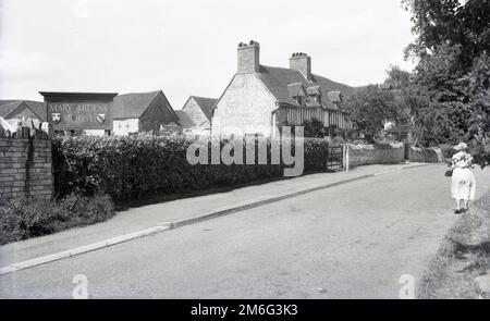 1950er, historisch, eine Dame, die an einer Straße vor Mary Arden's House steht, der Kindheit Heimat von Wilmcote, der Mutter des englischen Dramatikers William Shakespeares, in der Nähe von Stratford-upon-Avon, England, Großbritannien. Stockfoto