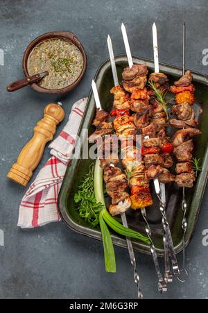 Gegrilltes Schweinefleisch, Huhn und Gemüsespieße auf dem Tablett. Draufsicht, flach liegend. Stockfoto