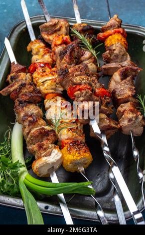 Gegrilltes Schweinefleisch, Huhn und Gemüsespieße auf dem Tablett. Draufsicht, flach liegend. Stockfoto