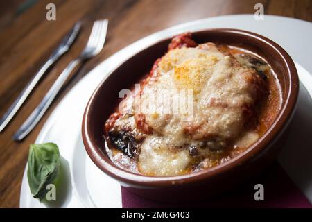 Parmigiana. Es ist wie eine Lasagne aus Auberginen, mit geriebenem Käse, Tomatensauce und Basilikumblättern Stockfoto