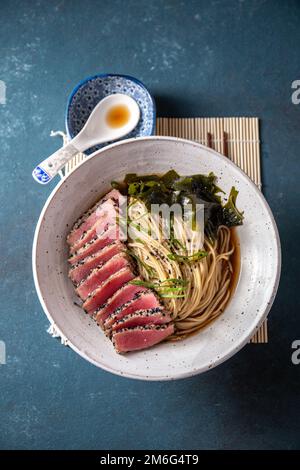 Thunfischsteak Ramen. Japanische Suppe mit Nudeln Ramen, Miso, gebratenem Thunfischsteak und Algen aus Algen. Stockfoto