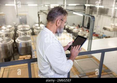 MTRA, der ein digitales Gerät in einer Fabrik verwendet Stockfoto