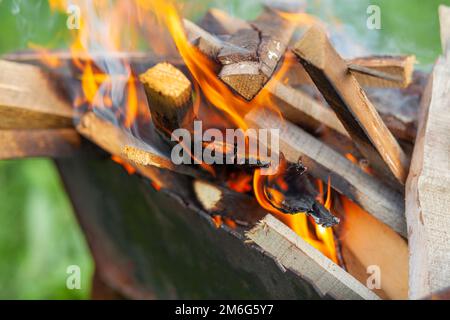 Das Feuerholz im Grill brennt mit einer leuchtend orangefarbenen Feuerflamme Stockfoto