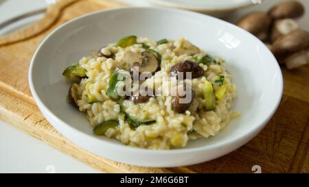 Risotto mit Pilzen und Gemüse. Risotto ist ein norditalienisches Reisgericht, das mit Brühe zubereitet wird, bis es eine cremige Konsistenz erreicht. Stockfoto