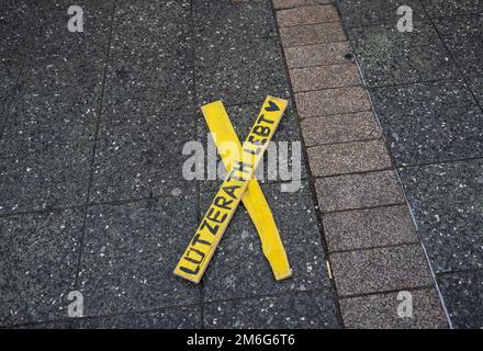 04. Januar 2023, Hessen, Frankfurt/Main: Ein gelbes Kreuz liegt auf dem Boden, während Teilnehmer einer Kundgebung zur Erhaltung des Dorfes Lützerath im rhenischen Braunkohlegebiet in Frankfurt demonstrieren. Das Dorf, das seit Jahren von Aktivisten besetzt ist, soll in absehbarer Zeit evakuiert werden. Foto: Boris Roessler/dpa Stockfoto