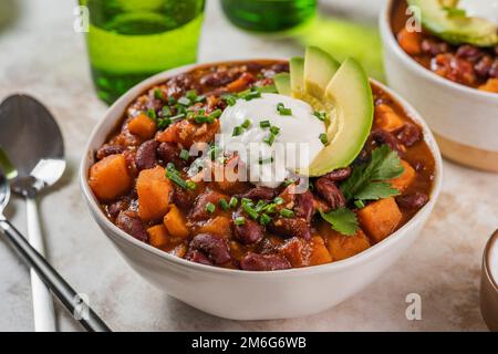 Chili Süßkartoffeln und schwarze Bohnen mit Tomaten, Sellerie in einer Pfanne auf dem Tisch. Horizontale Draufsicht von oben Stockfoto