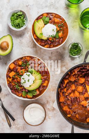 Chili Süßkartoffeln und schwarze Bohnen mit Tomaten, Sellerie in einer Pfanne auf dem Tisch. Horizontale Draufsicht von oben Stockfoto
