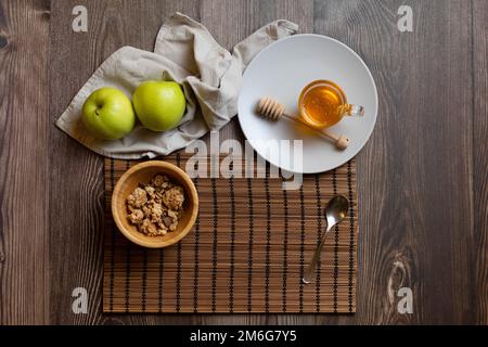 Essen Sie den Tag mit einem gesunden Frühstück mit Honig Müsli und Äpfeln Stockfoto