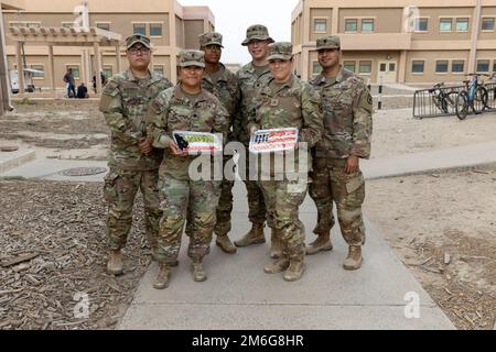 CAMP ARIFJAN, KUWAIT, USA Armeesoldaten, die dem 3. Bataillon, dem 157. Artillerie-Regiment, zugeteilt wurden, feiern das Ende des täglichen Fastens während des Ramadan, indem sie Iftar mit unseren Gastgebernationspartnern Kuwait Land Forces im Camp Arifjan, Kuwait, am 27. April 2022 teilen. Iftar ist die Mahlzeit, um das tägliche Fasten während des Ramadan zu brechen und wird jeden Abend nach Sonnenuntergang abgehalten. Stockfoto