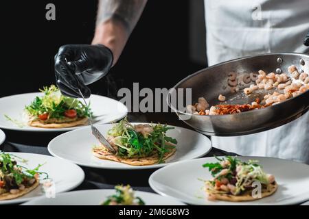 Der Koch im Restaurant macht scharfe Shrimp Tacos mit Krautsalat und Salsa Stockfoto