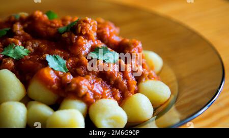 Gnocchi mit Bolognessoße und Tomate. Traditionelles italienisches Rezept. Stockfoto