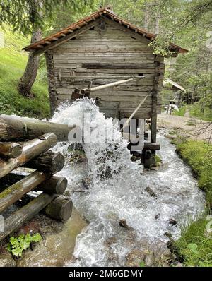 Wasser rauscht durch eine Holzhütte im Wald Stockfoto