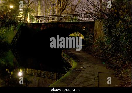 Blick auf einen Fußweg unter einer Brücke am Regent's Canal bei Nacht in North London, Camden Stockfoto