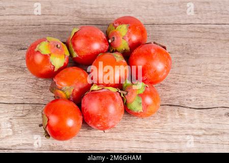 Persimonen auf Holztischhintergrund Stockfoto