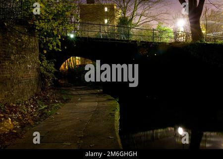 Blick auf einen Fußweg unter einer Brücke am Regent's Canal bei Nacht in North London, Camden Stockfoto