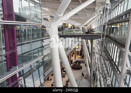 Reisende fahren durch das Heathrow Airport Terminal 5 in London Stockfoto