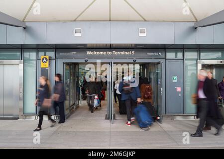 Reisende fahren durch das Heathrow Airport Terminal 5 in London Stockfoto