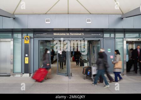 Reisende fahren durch das Heathrow Airport Terminal 5 in London Stockfoto