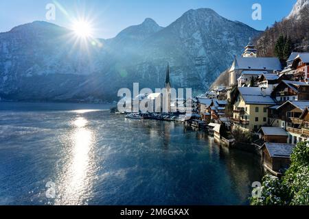 Wunderschöne sonnige Stadtlandschaft der besonderen Stadt Hallstatt in Österreich Salzkammergut verschneite Winterberge, See und Kirche Stockfoto