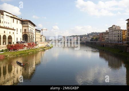 Die Ruderfahrer trainieren auf dem Fluss Arno in Florenz bei Sonnenschein im Herbst an klaren Tagen Stockfoto