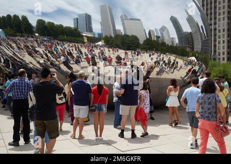 Touristen fotografieren vor Cloudgate, auch bekannt als The Bean, von Anish Kapoor im Millennium Park in Chicago Stockfoto