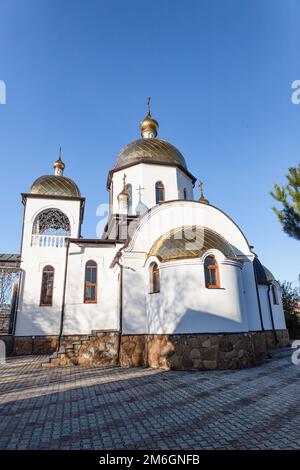 Orthodoxe Kirche mit weißen Lagern, Glockenturm und vergoldeten Kuppeln Stockfoto