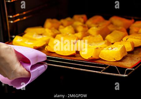 Kürbisscheiben auf einem Backblech im Ofen gebacken. Hausgemachte Speisen Stockfoto