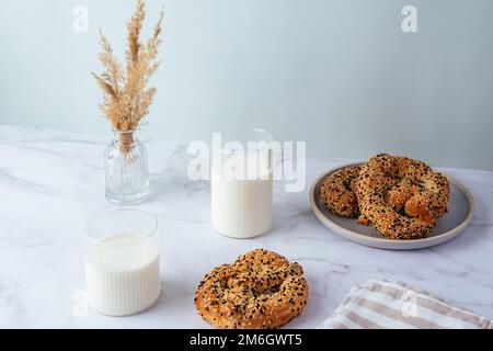 Milch in einem Glas, Brezel mit Sesamsamen Stockfoto