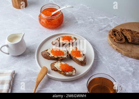 Kleine Baguette-Sandwiches mit Butter und rotem Kaviar Stockfoto