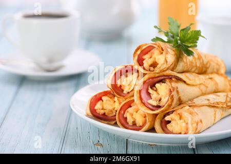 Hausgemachte dünne Pfannkuchen mit einer Scheibe Schinken und Rührei Stockfoto