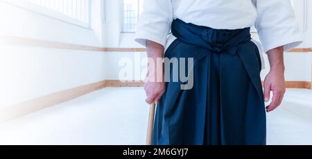 Mann, der Aikido in einem Dojo-Hintergrund übt. Stockfoto