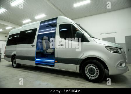 Komfortables Interieur für Personenbusse mit gepolsterten Sitzen; individueller Transfer für eine Gruppe von Personen; Umbau des Innenraums eines Lkws; Stockfoto